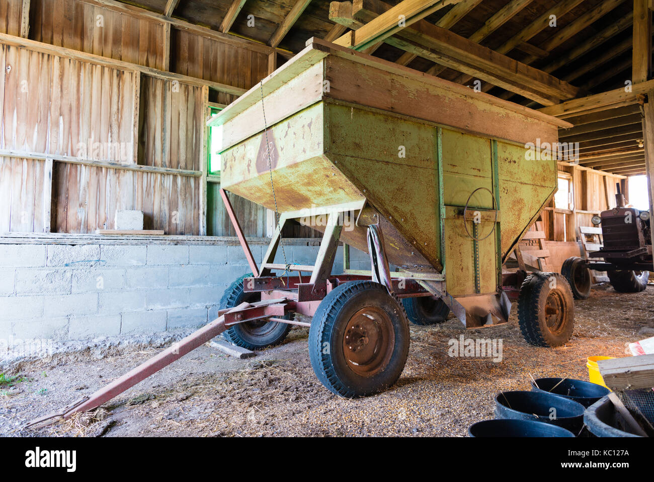 old rusty grian wagon sitting inside a barn Stock Photo