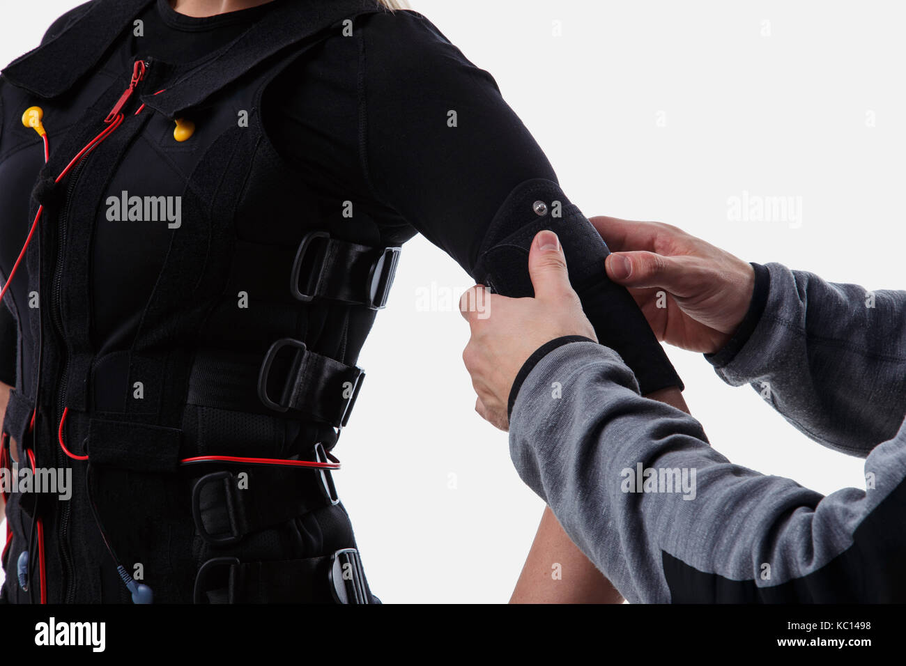 Trainer helps woman attaching electrode on ems suit, isolated on white background Stock Photo