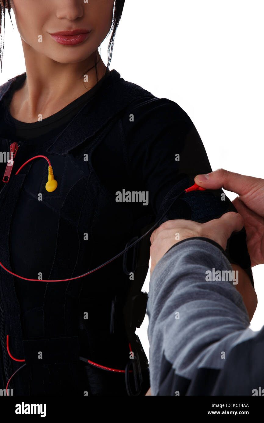 Trainer helps woman attaching electrode on ems suit, isolated on white background Stock Photo