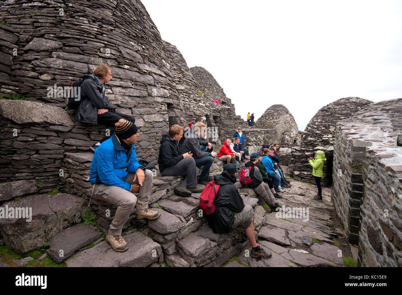 Visitors listening to the guide at ancient monastery in Skellig Michael Island, County Kerry, Ireland Stock Photo