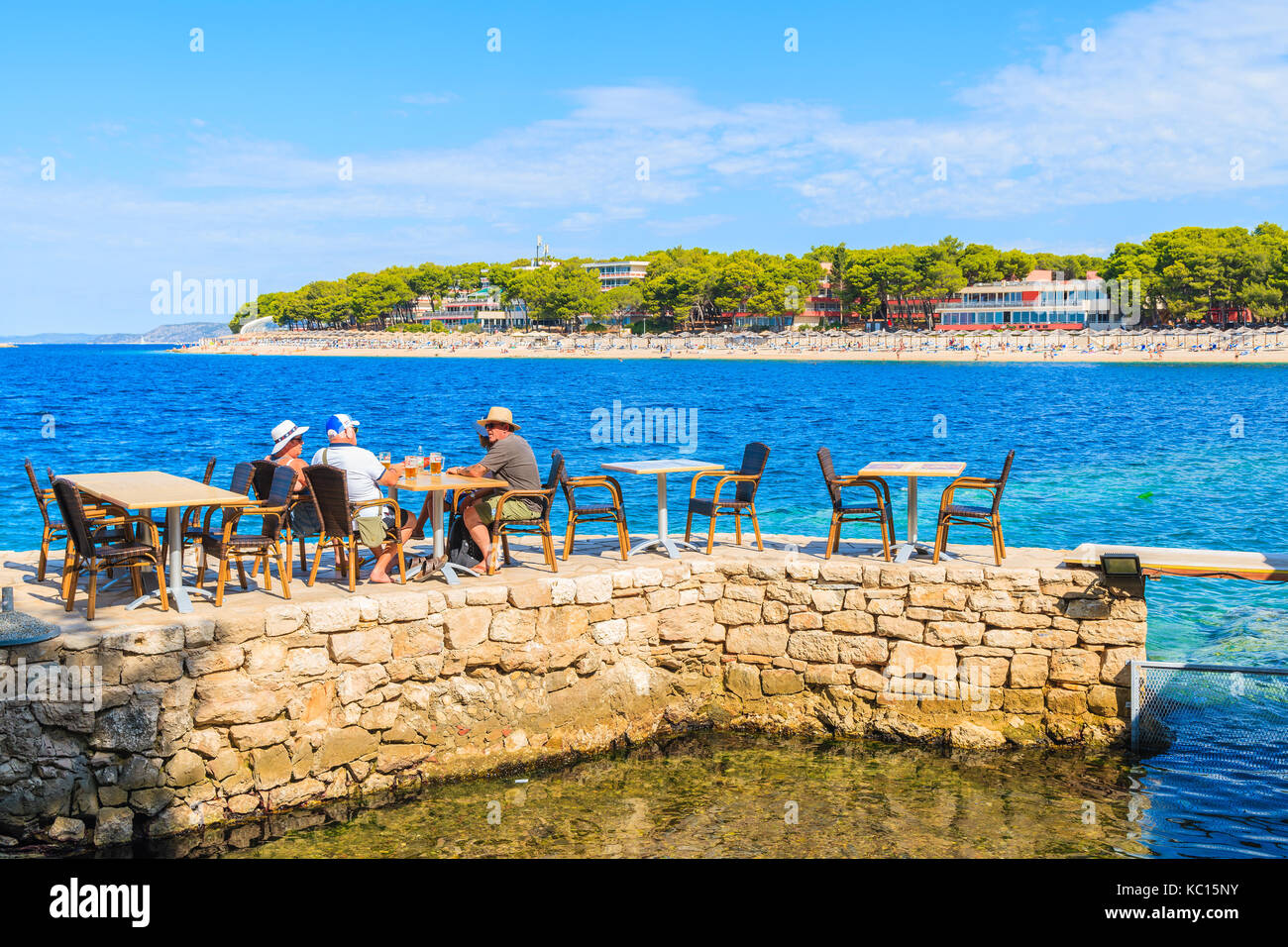 PRIMOSTEN, CROATIA - SEP 5, 2017: tourists sitting in coastal bar and drinking beers in Primosten town, Dalmatia, Croatia. Stock Photo