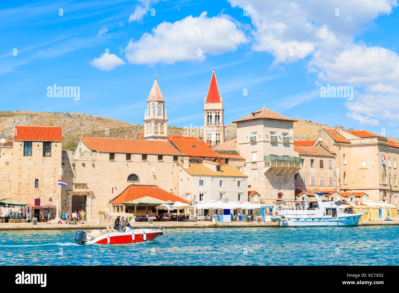 Motorboat sailing on sea along Trogir old town with historic buildings, Dalmatia, Croatia Stock Photo