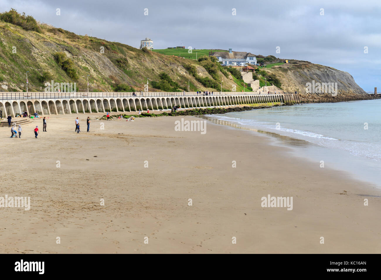 People on the beach, view of Folkestone Sunny Sands from the harbour arm. Kent England UK Stock Photo