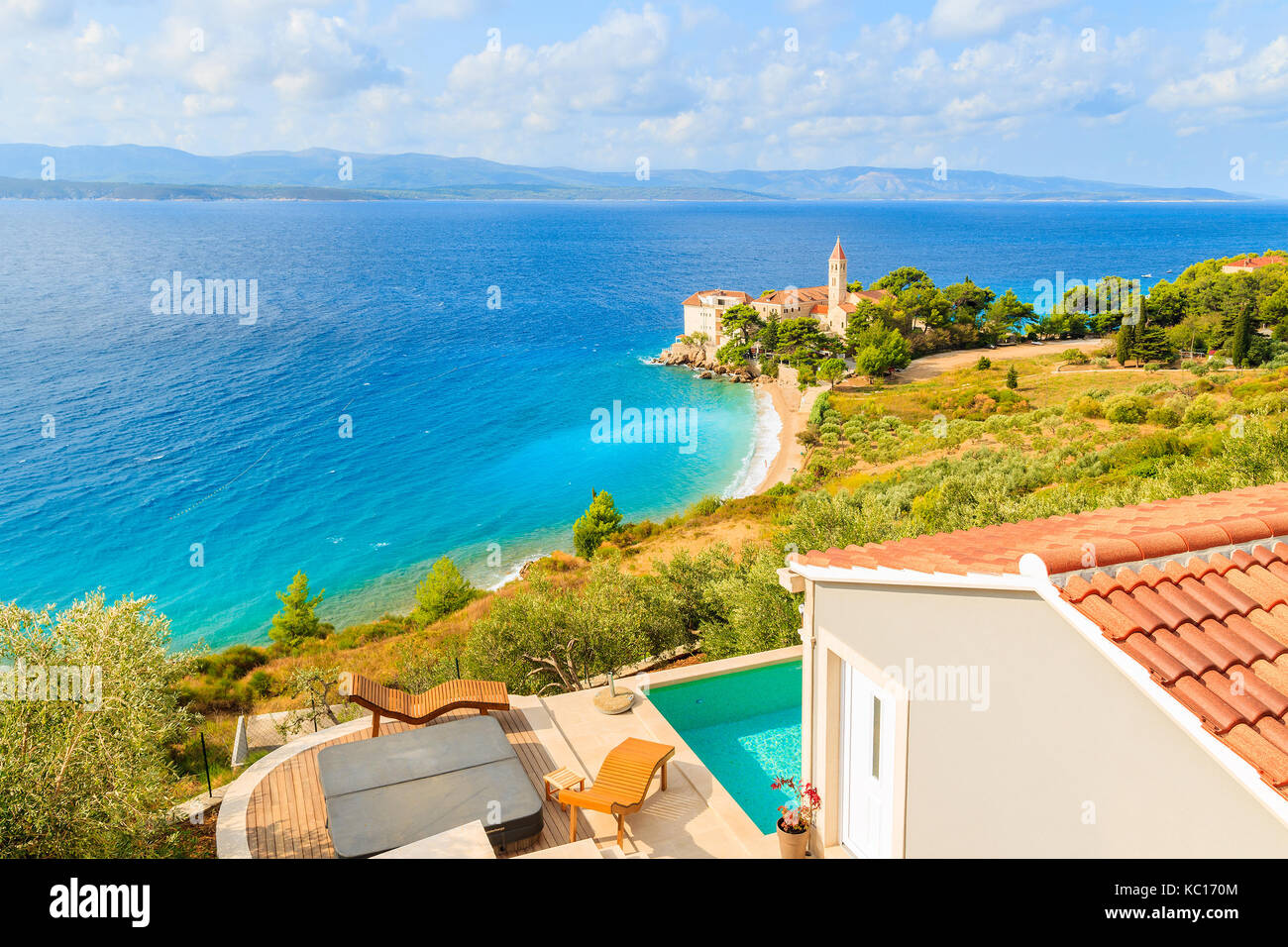 View of famous Dominican monastery on beach in Bol town with holiday apartment terrace in foreground, Brac island, Croatia Stock Photo