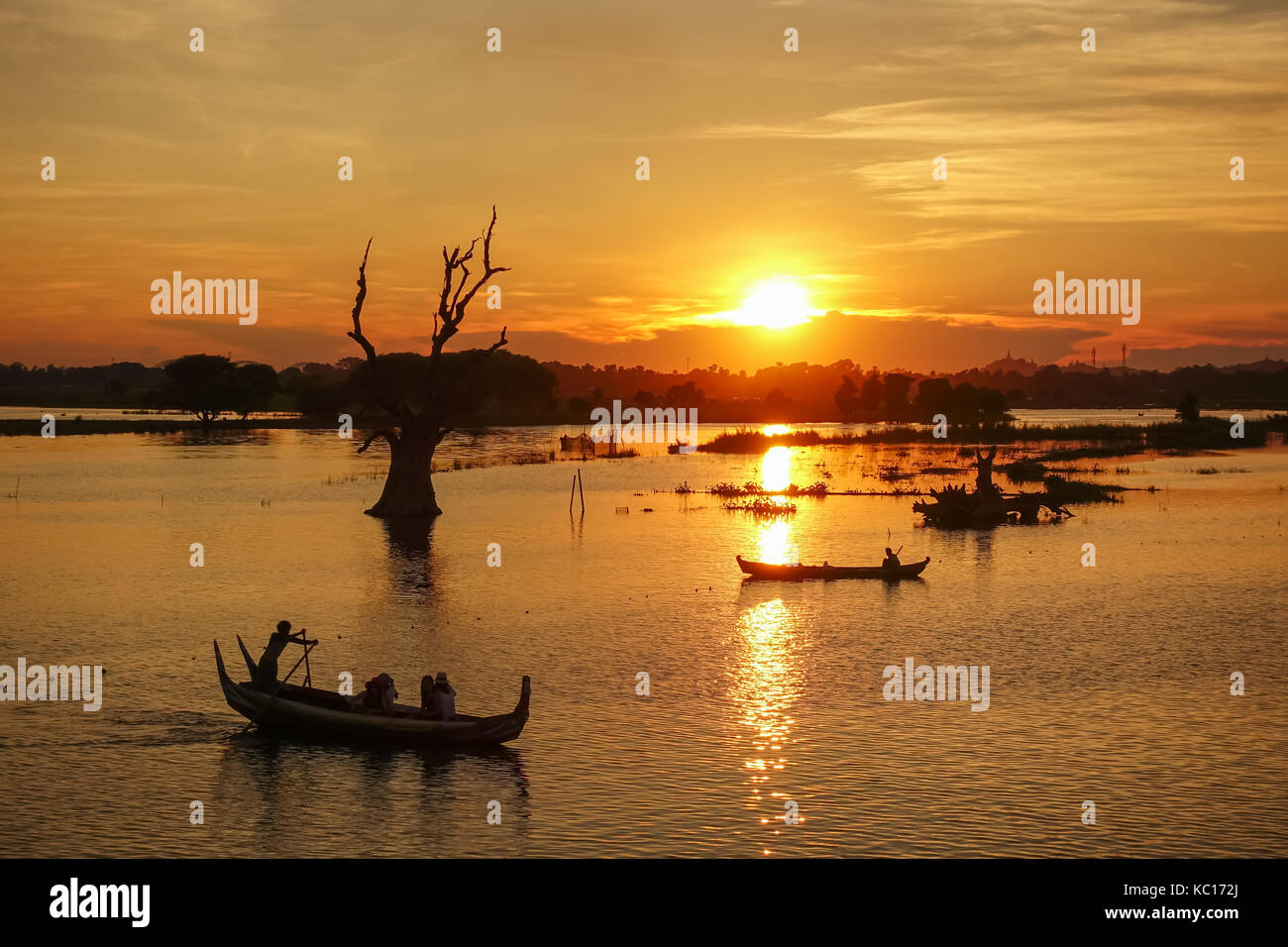 Sunset landscape with boats near famous U Bein bridge near Mandalay in Myanmar Stock Photo