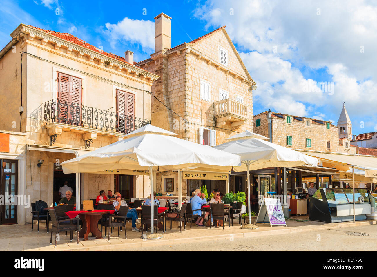 SUPETAR PORT, CROATIA - SEP 12, 2017: people dining in restaurant in Supetar port during late summer afternoon, Brac island, Croatia. Stock Photo