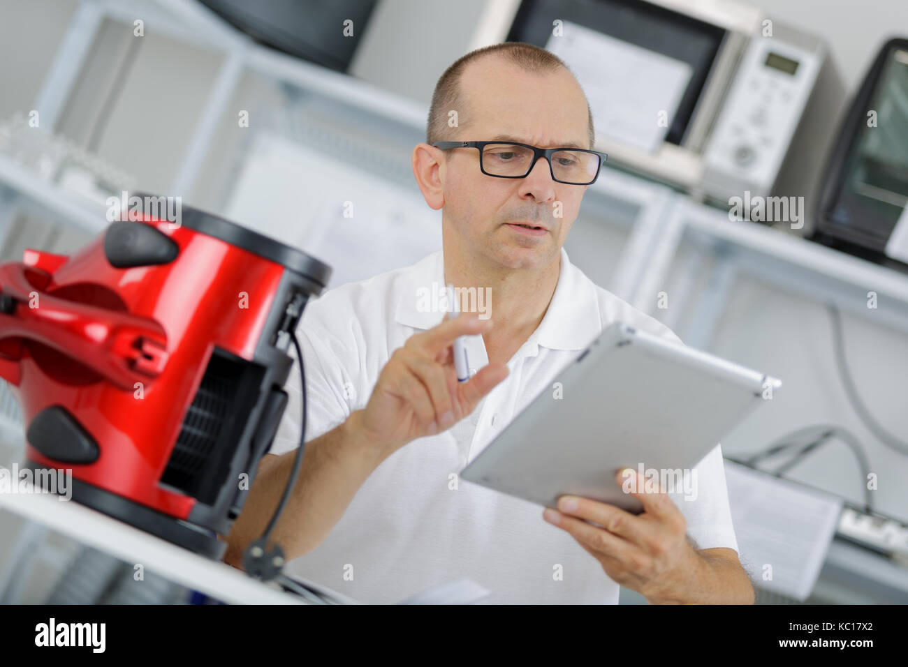 technician checks his table to fix a vaccum cleanner Stock Photo