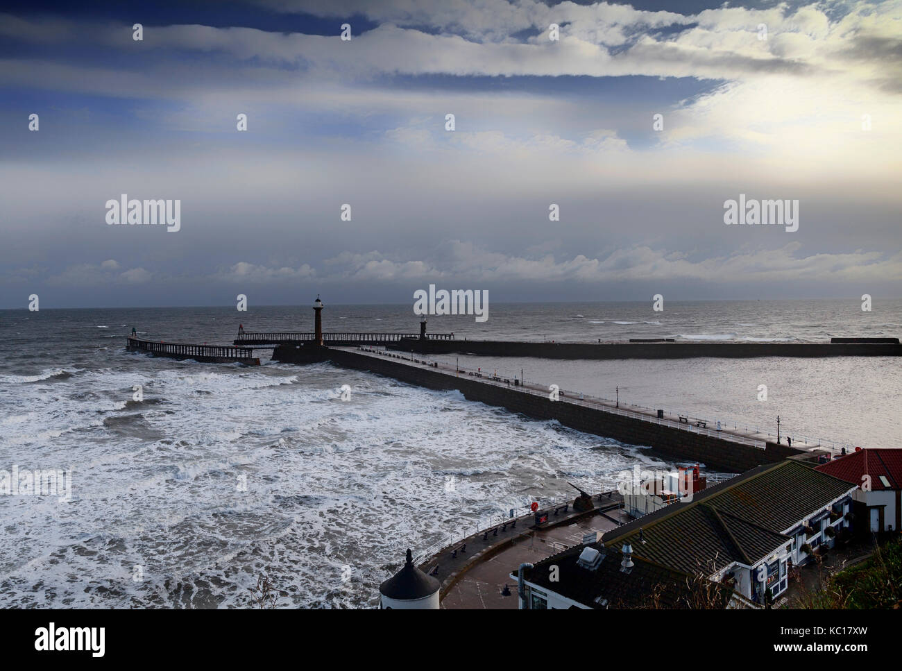 Stormy seas surround the Whitby Piers, East And West. The West Pier itself was built using sandstone blocks in 1632 and almost rebuilt by Mr Francis P Stock Photo