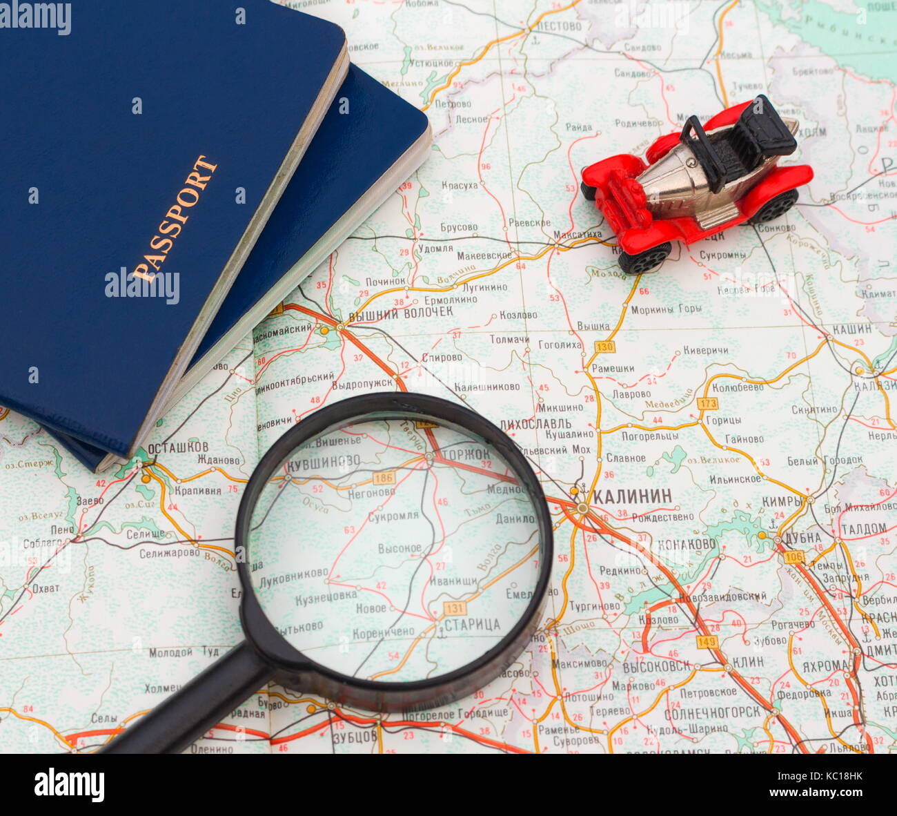 Toy car with two passports and magnifying glass on map. Travel around the world. Stock Photo