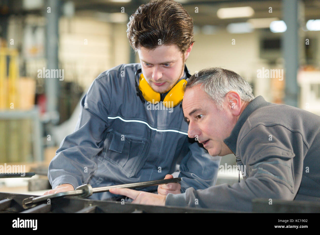 man working with apprentice in printing house Stock Photo - Alamy