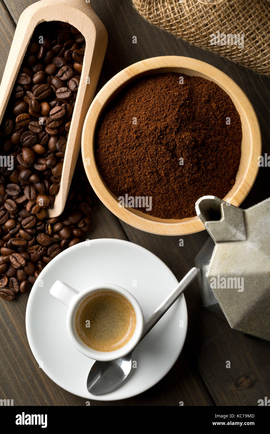Coffee beans, ground coffee powder and cup of espresso with stovetop