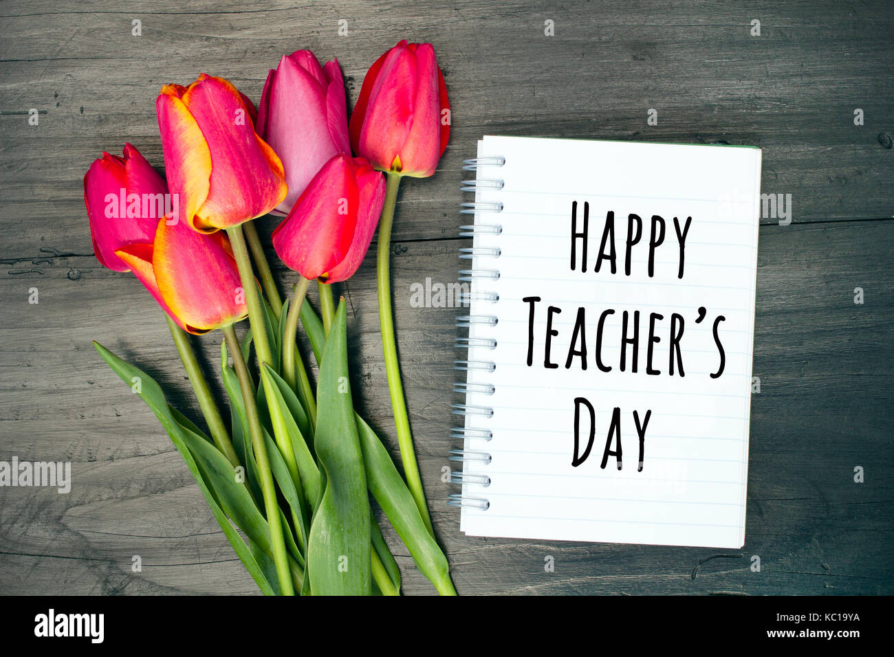 happy teacher's day card with tulip bouquet and notebook on