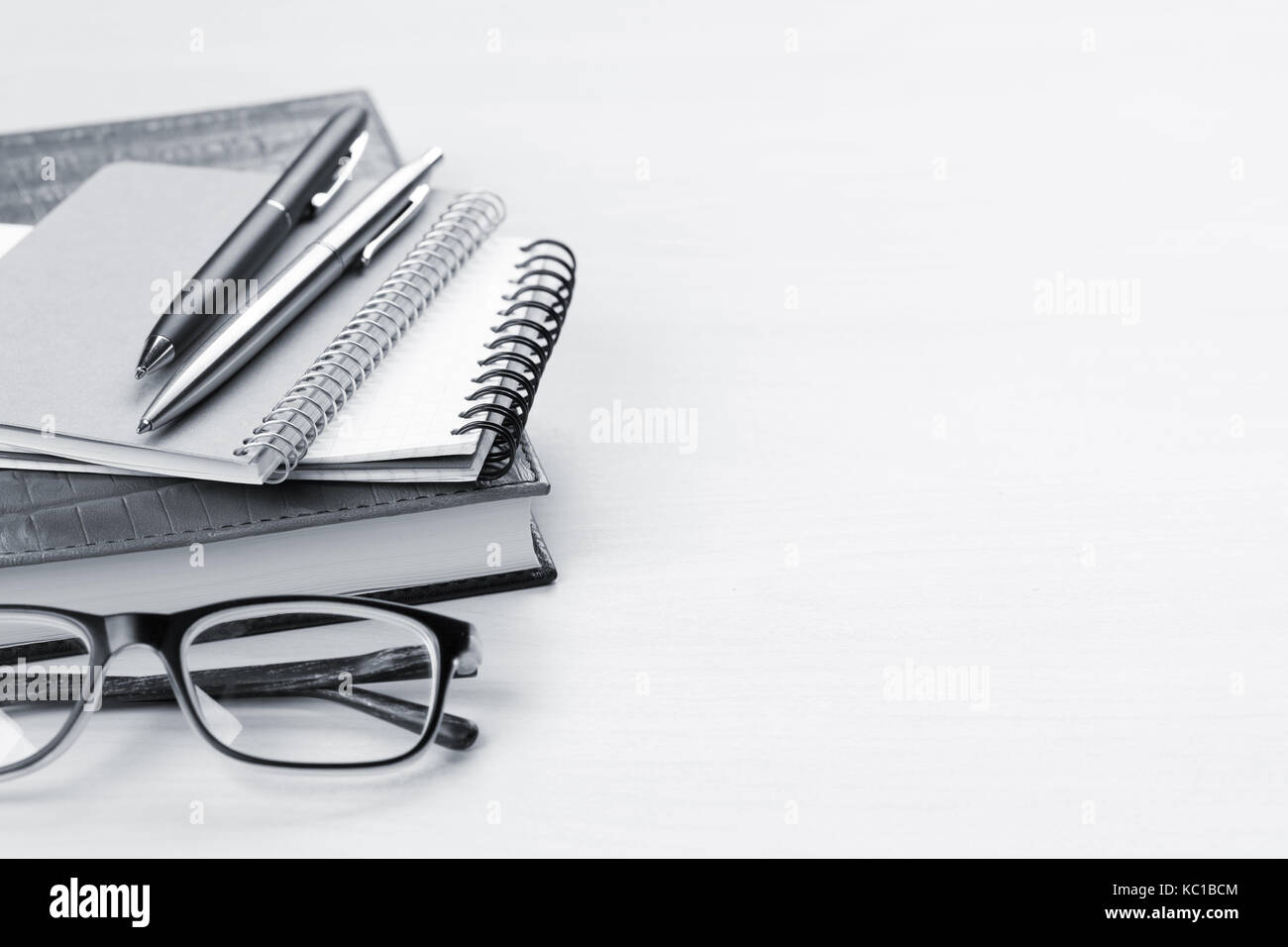 Wooden office desk with supplies. Notepad, pen and glasses. With space for your text. Toned