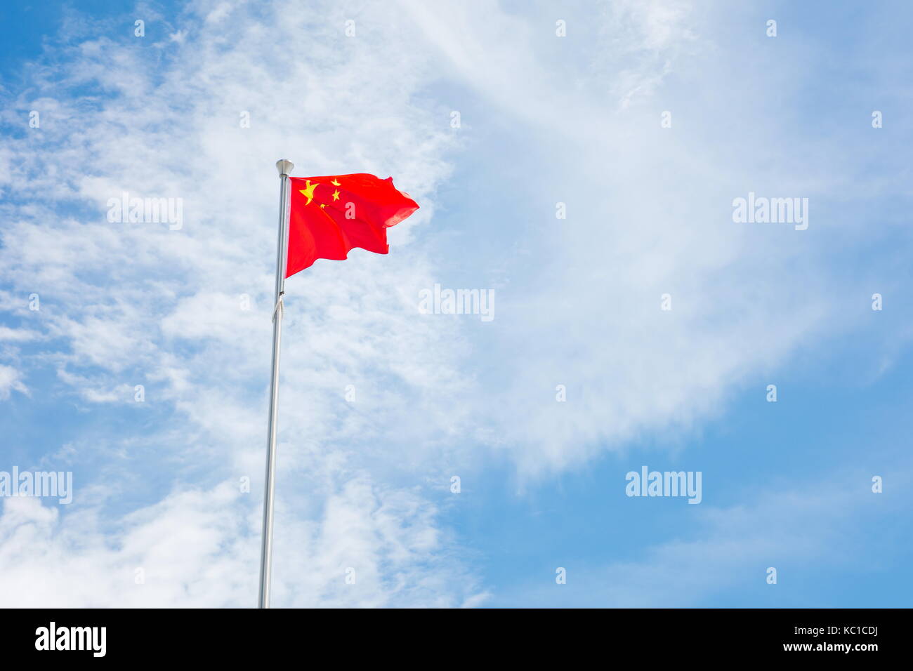 Chinese flag floating on the wind against blue  sky Stock Photo