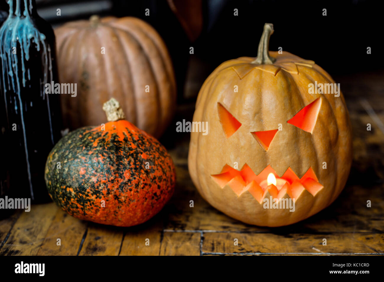Family of Halloween pumpkin head jack lantern near candlestick bottles ...