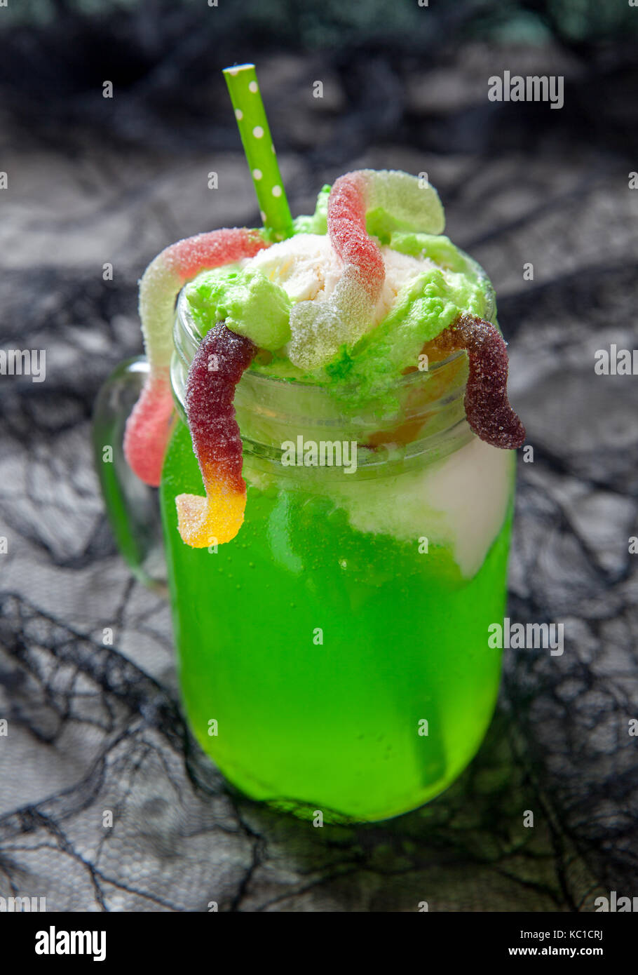 Green drink with ice cream float and gummy worms for Halloween Stock