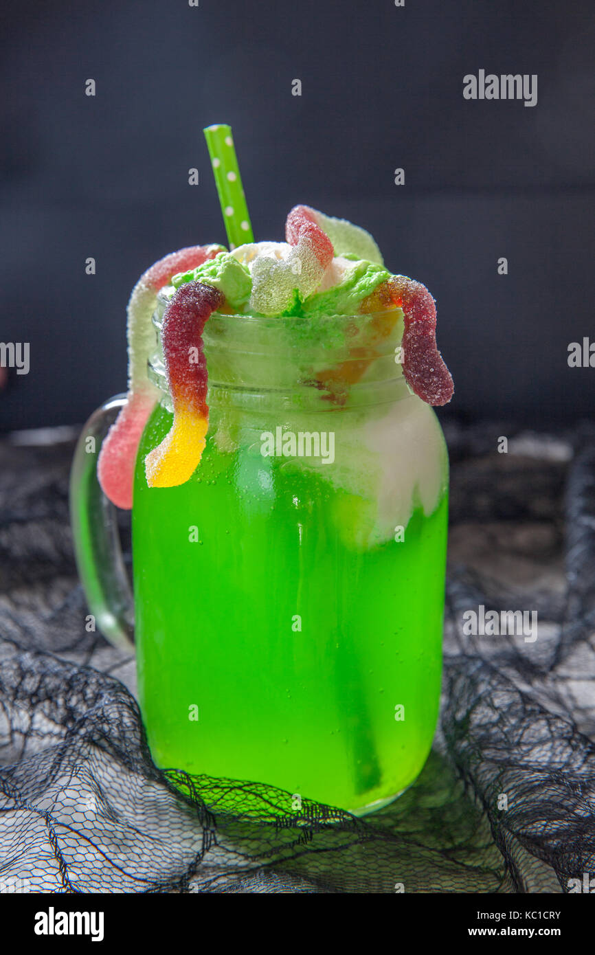 Green drink with ice cream float and gummy worms for Halloween Stock