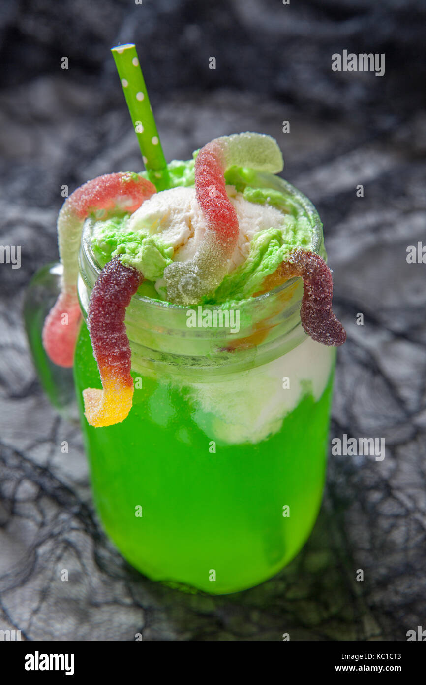 Green drink with ice cream float and gummy worms for Halloween Stock