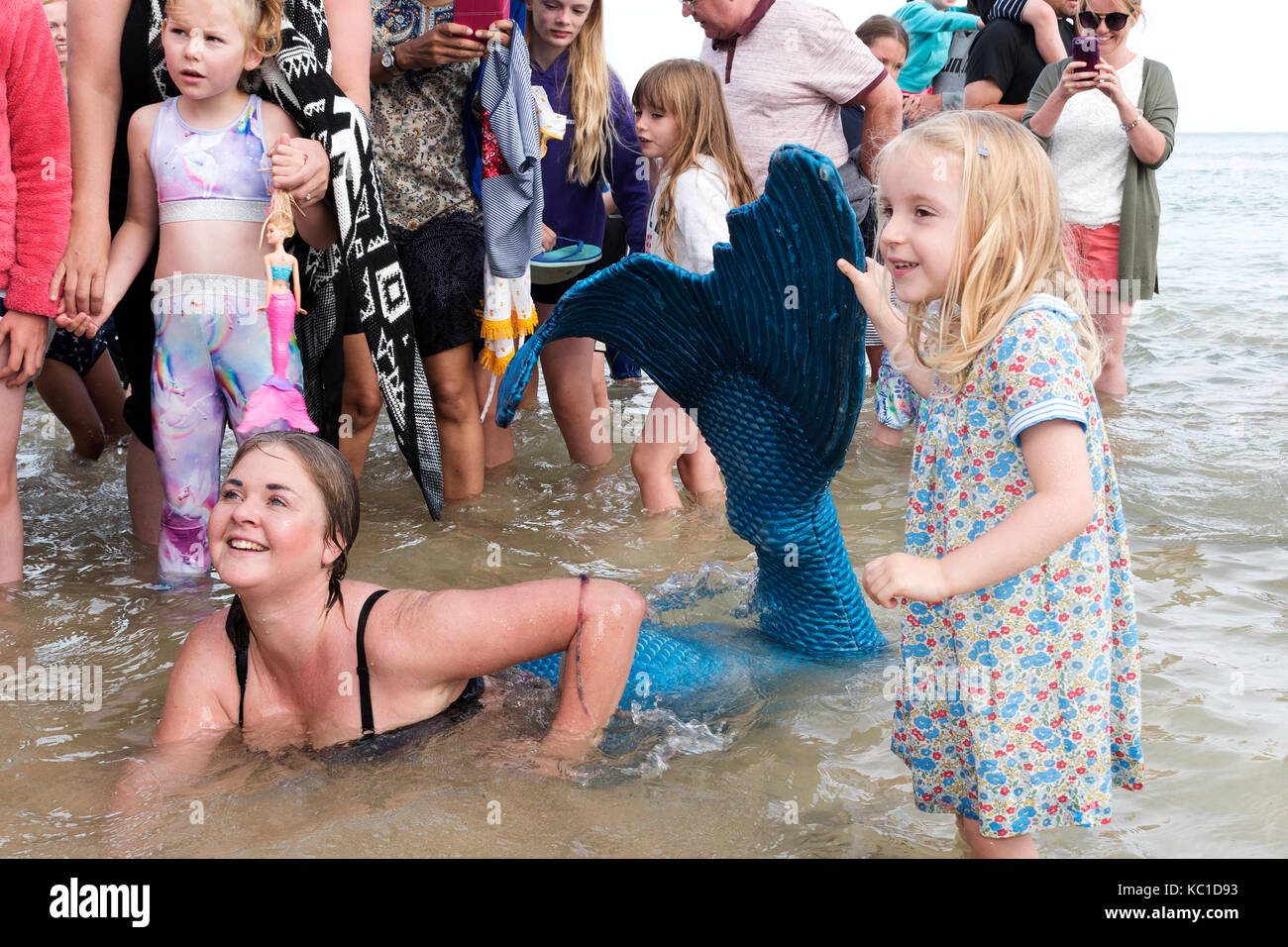 a young woman in fancy dress as a mermaid meets and greets children on the beach at st,ives in cornwall, england, uk, Stock Photo