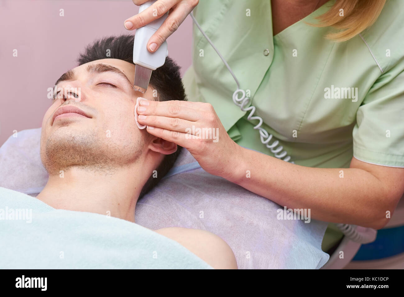 Hands using ultrasonic face scrubber. Stock Photo