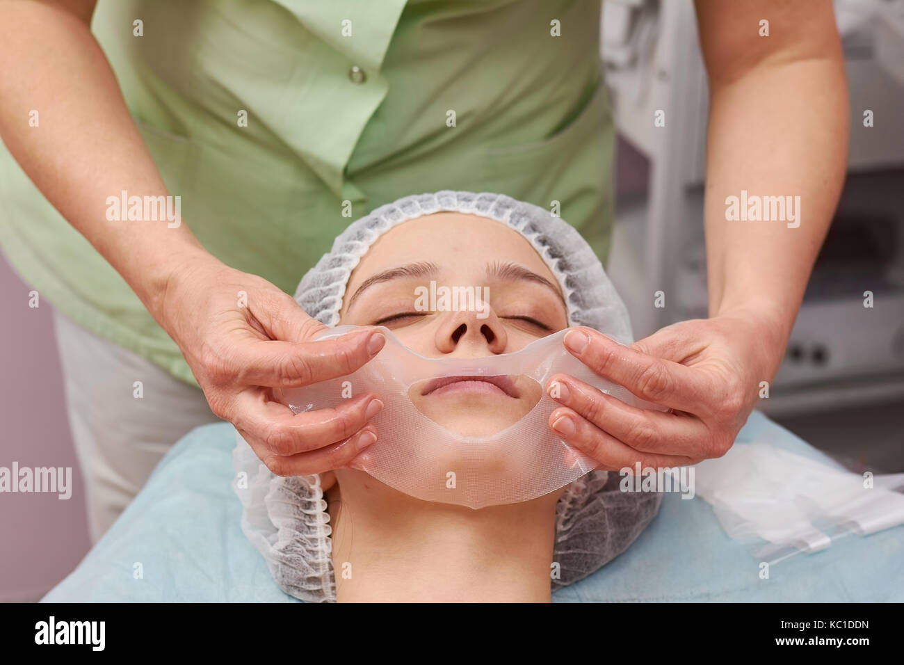 Hands of cosmetician, collagen mask. Stock Photo