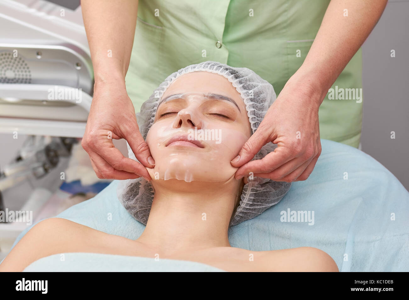 Cosmetician working, collagen mask. Stock Photo