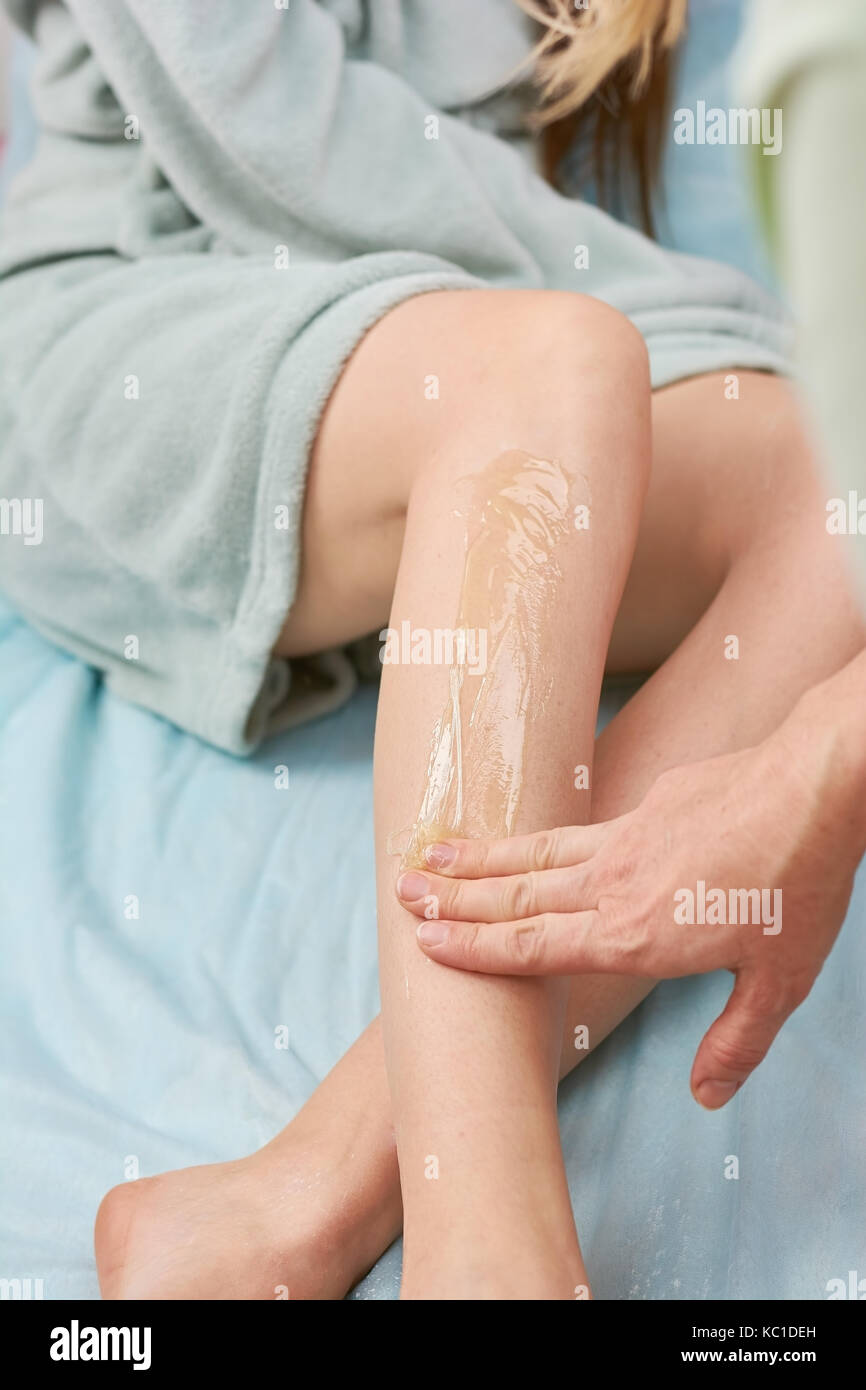 Leg sugaring, hand of cosmetician. Stock Photo