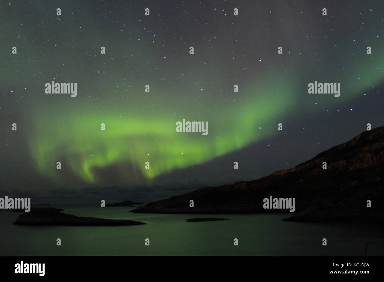 Northern lights over mountains and fjords in Tromso Stock Photo