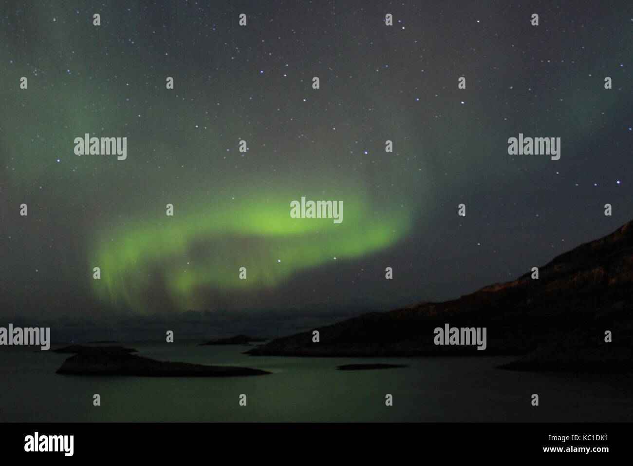 Northern lights over mountains and fjords in Tromso Stock Photo