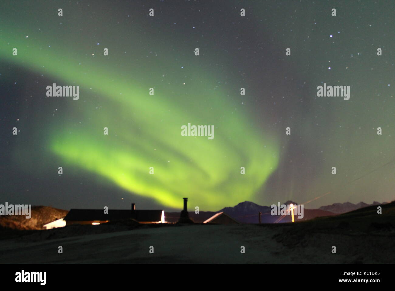 Northern lights over rooftops near Tromso Stock Photo