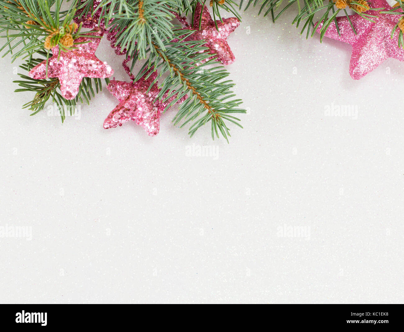 Pink star shaped ornaments hanging on a fir branch.Christmas celebration time. Stock Photo