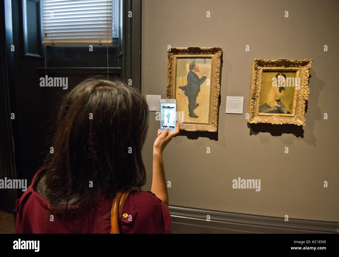 A woman taking a photo of Degas paint 'Carlo Pellegrini' Stock Photo