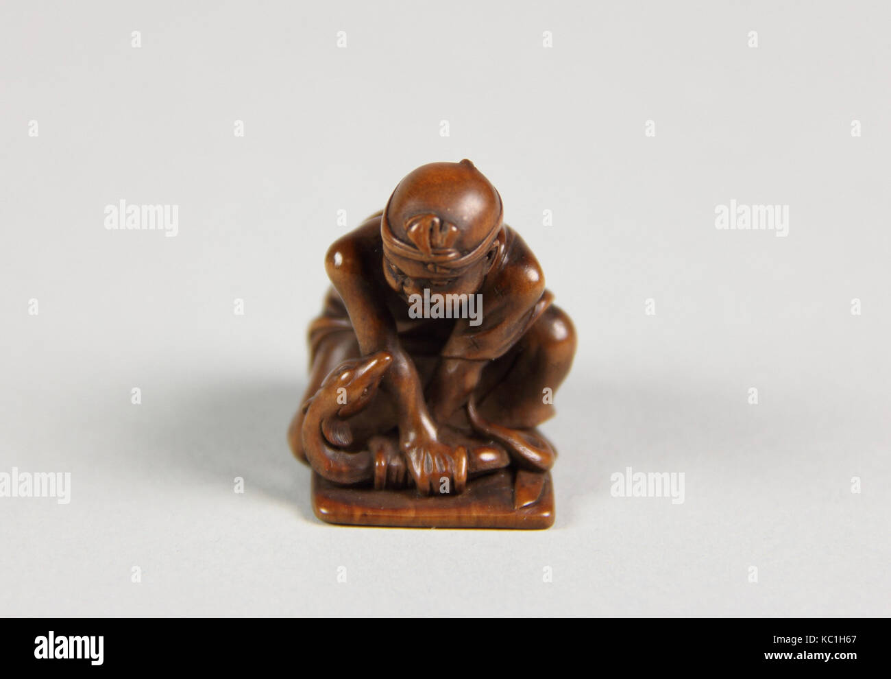 Netsuke of Boy with a Snake, 19th century, Japan, Wood, H. 1 1/3 in. (3.4 cm), Netsuke Stock Photo