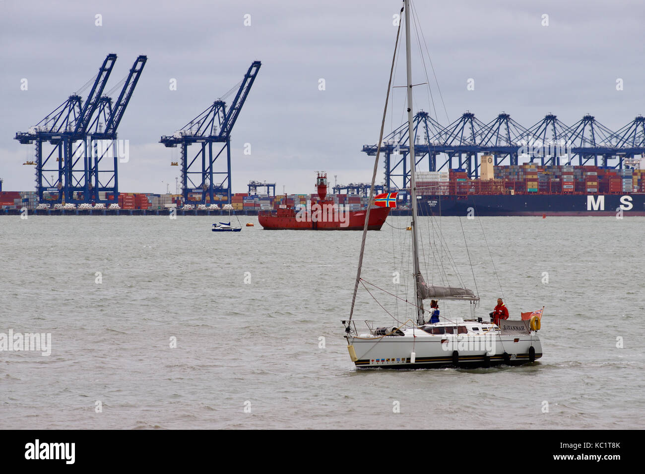 Suffolk, UK. 1st October, 2017. UK weather : Sailing dinghy Savannah coming into Shotley Gate marina on the River Orwell. Felixstowe port is visible in the background as well as a red lightship. Suffolk, UK. Credit: Angela Chalmers/Alamy Live News Stock Photo