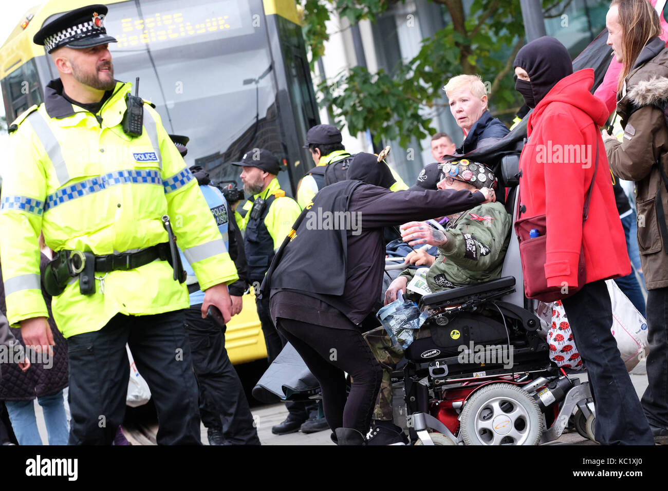 St Peters Square, Manchester, UK - Sunday 1st October 2017 - An anti government protester in a wheelchair receives support from another protester whilst obstructing the tram network in Manchester city centre - Police prepare to clear the protesters outside the Conservative Party Conference. Photo Steven May / Alamy Live News Stock Photo