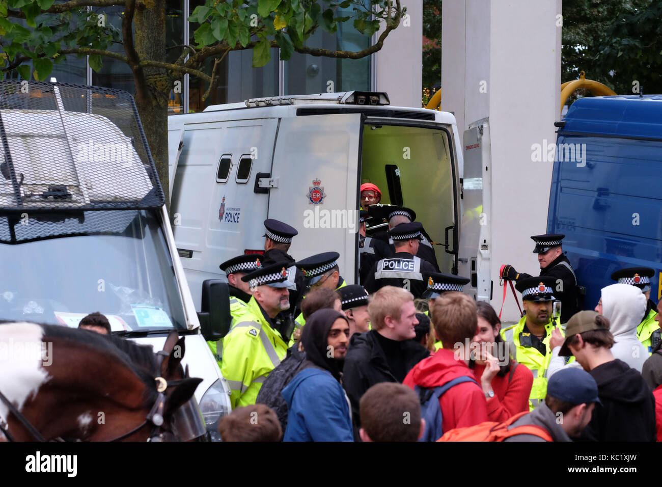 St Peters Square, Manchester, UK - Sunday 1st October 2017 - Police officers detain a wheelchair bound protester inside a police van after tram tracks were obstructed by protesters outside the Conservative Party Conference. Photo Steven May / Alamy Live News Stock Photo