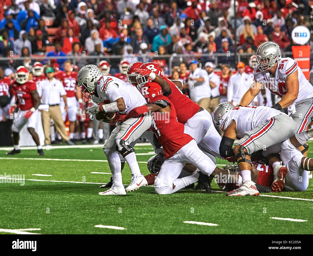 Piscataway, New Jersey, USA. 30th Sep, 2017. Ohio State's quarterback J.T. Barrett (16) is tackled by Rutgers defensive back K.J. Gray (17) play during NCAA football action between the Ohio State Buckeyes and the Rutgers Scarlet Knights at High Point Solution Stadium in Piscataway, New Jersey. Duncan Williams/CSM/Alamy Live News Stock Photo