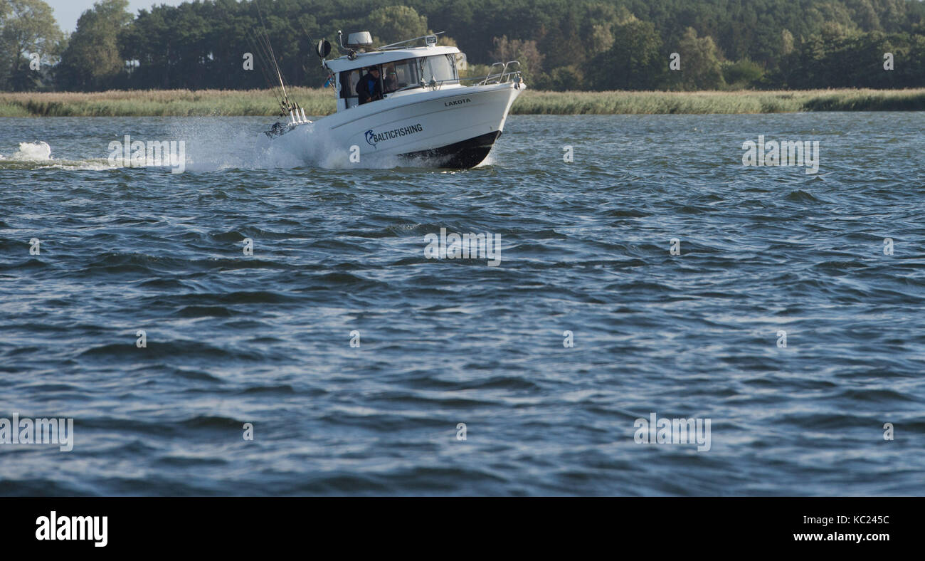 A fishing boat crosses the river Pennestrom at the island Usedom in