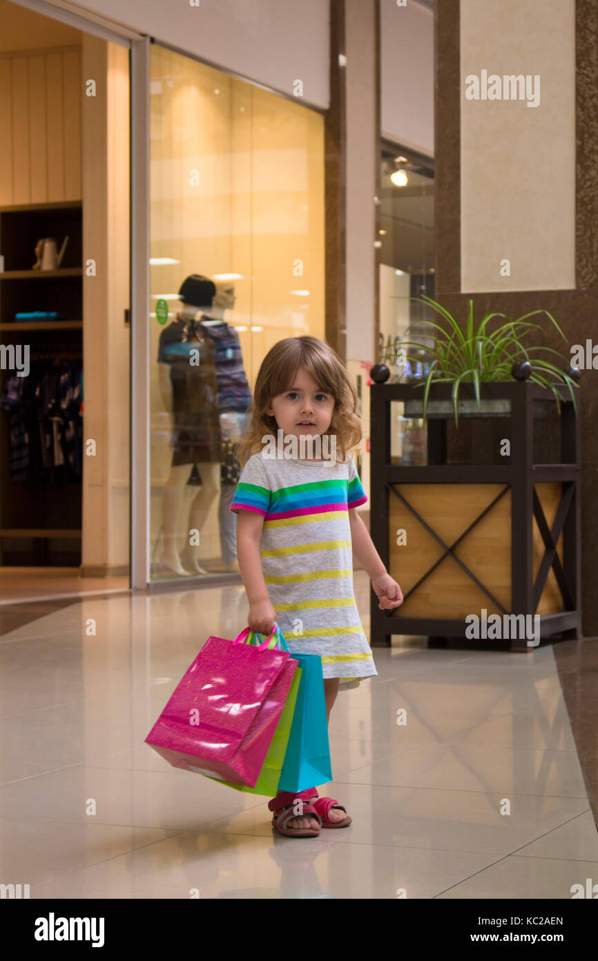 Happy girl holding shopping bags at the mall Stock Photo - Alamy