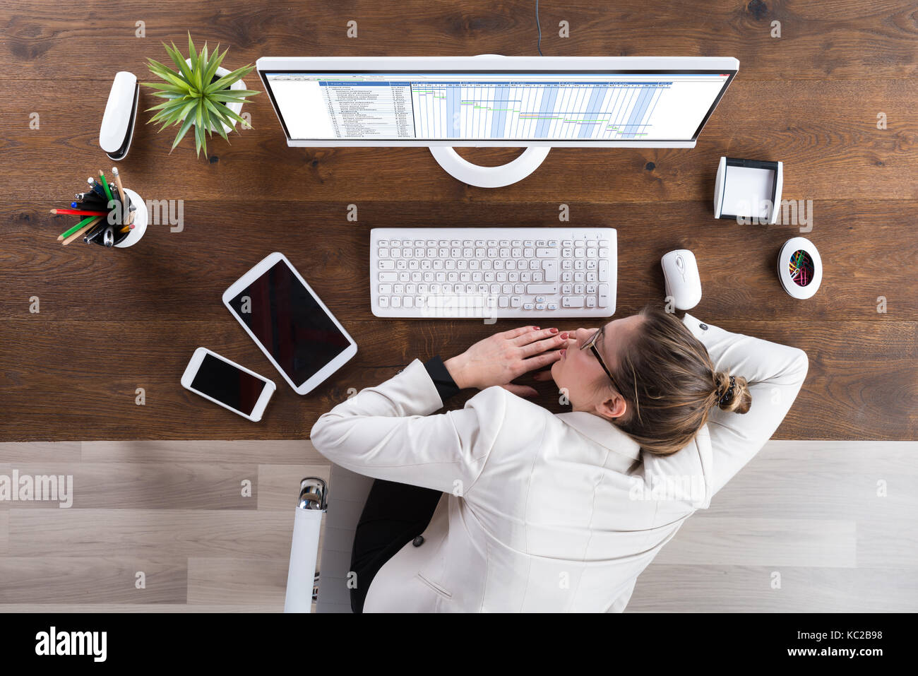 Young Businesswoman Sleeping In Front Of Computer At Desk Stock Photo