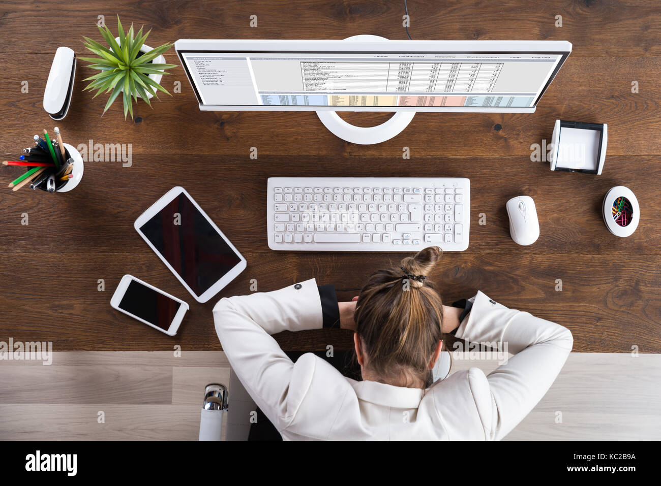 Young Businesswoman Sleeping On Desk At Workplace Stock Photo