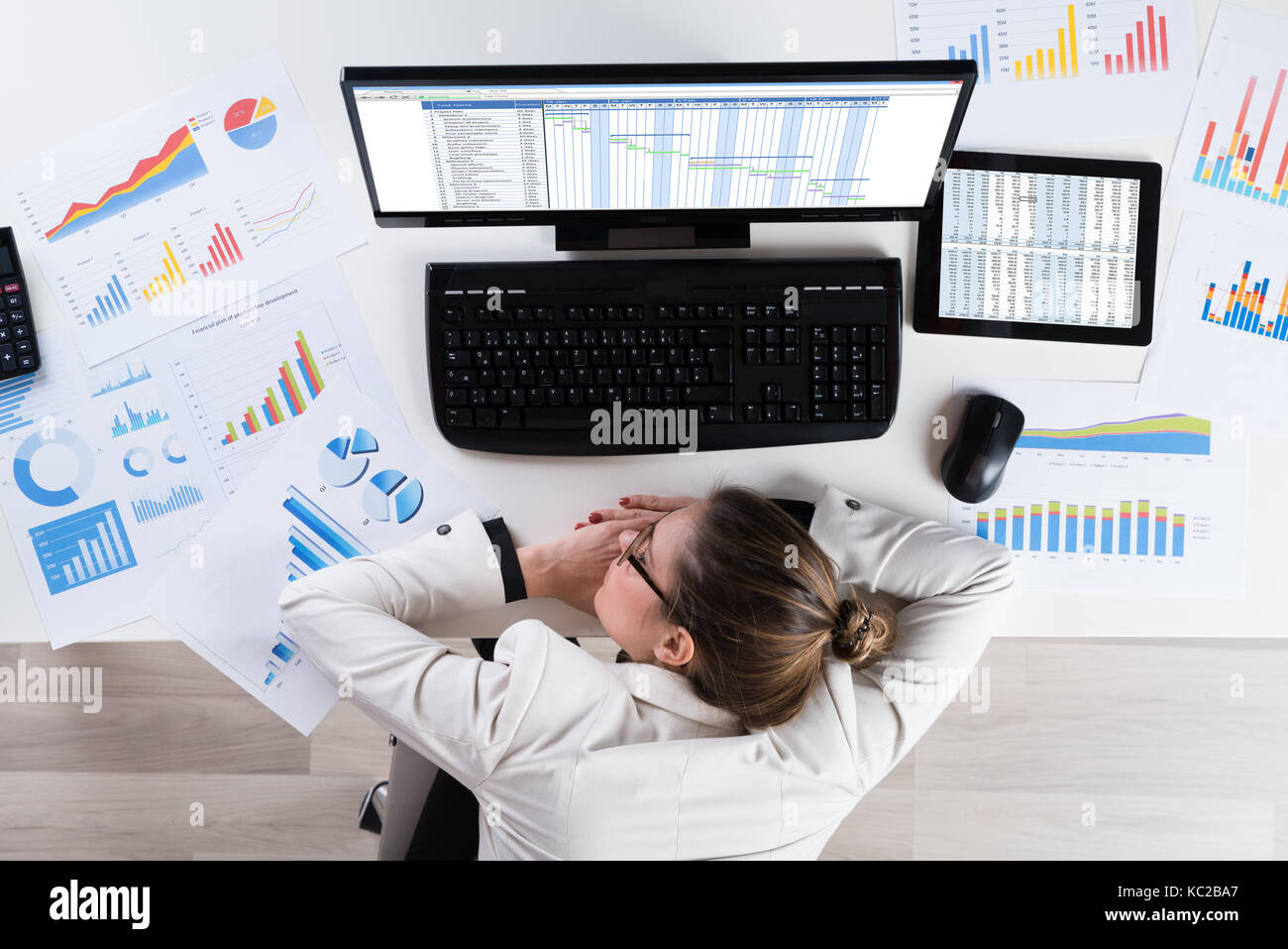 Young Businesswoman With Graphs Sleeping At Desk In Office Stock Photo ...