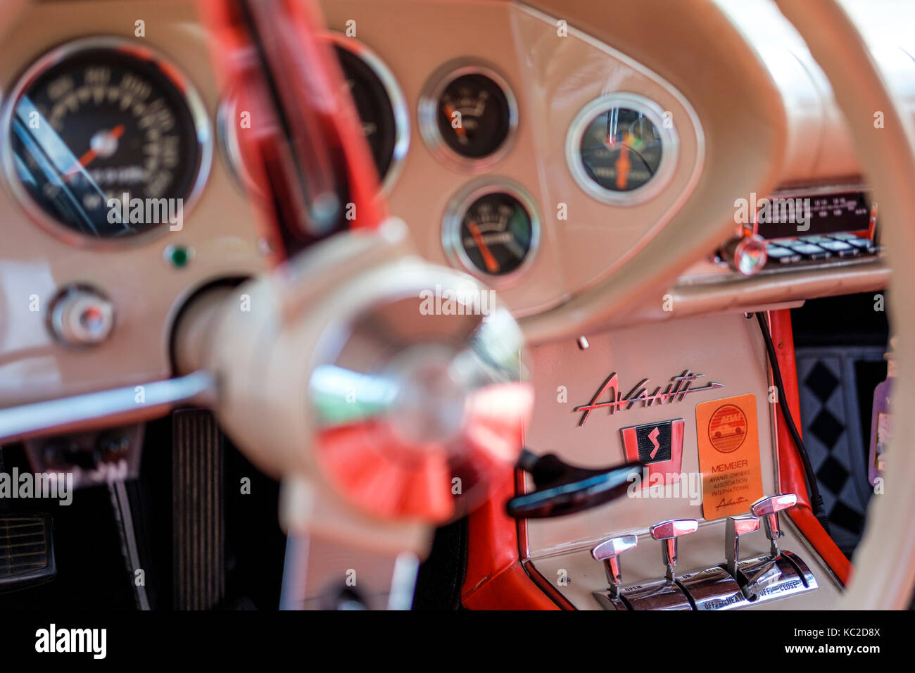 White 1963 Studebaker Avanti S panel showing steering wheel, dials,  driver controls, and Avanti logo. Stock Photo