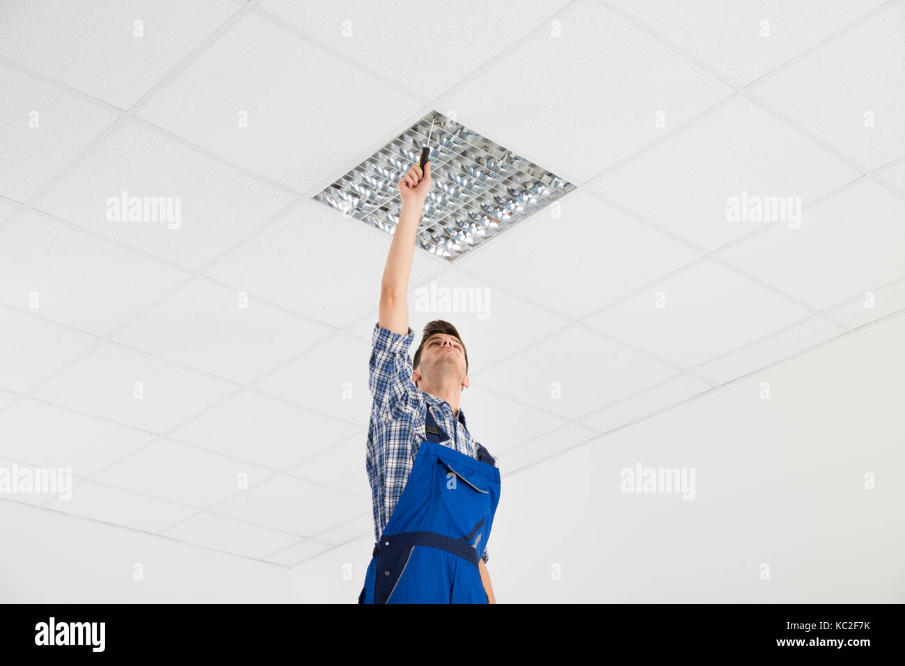 Male Electrician On Stepladder Installing Ceiling Light Stock Photo - Alamy