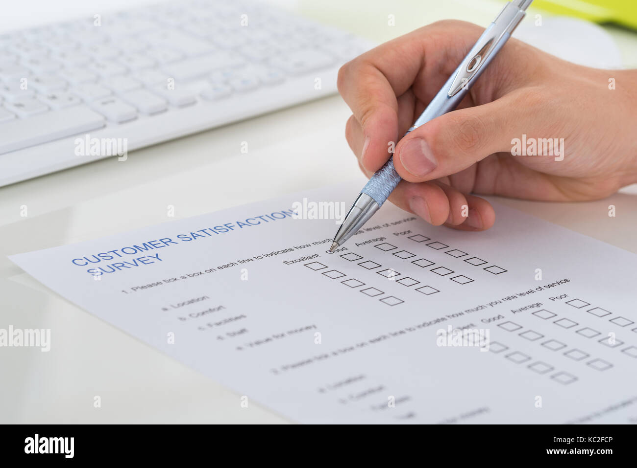 Close-up Of Person Hands Filling Survey Form With Pen Stock Photo