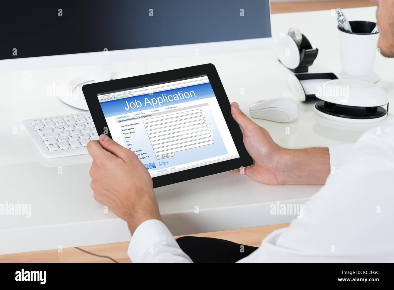 Close-up Of Businessman Filling Online Job Application Form On Digital Tablet Stock Photo