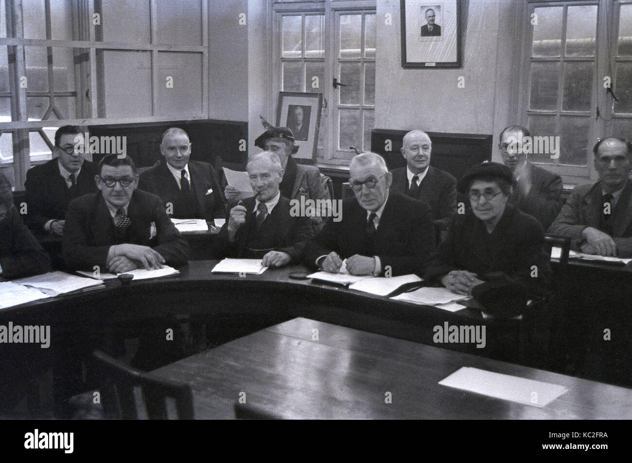 1960s, historical, smartly dressed local councilors sit behind circular desks with notes at a town council meeting, England, UK. Stock Photo