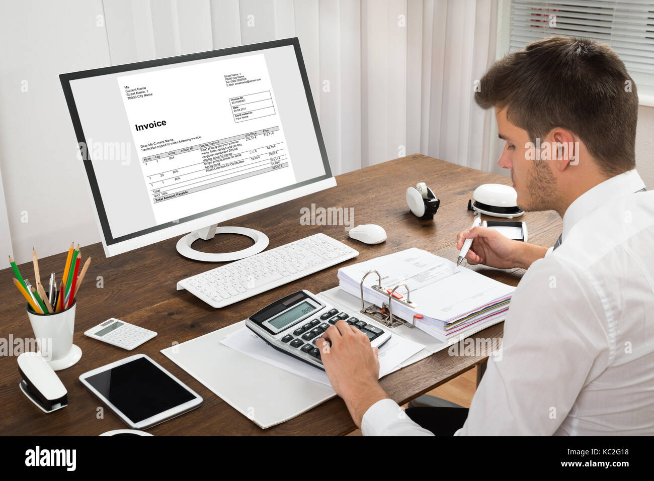 Male Accountant Calculating Tax In Front Of Computer At Desk Stock Photo - Alamy