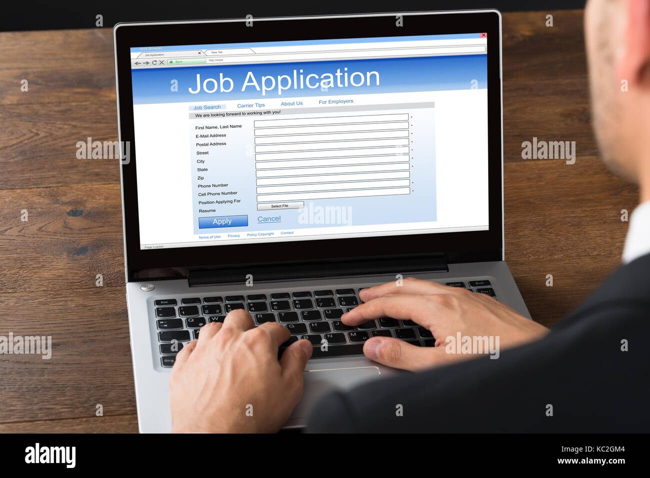 Close-up Of Businessman Filling Online Job Application Form On Laptop Stock Photo