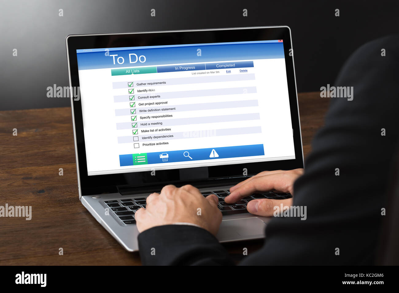Close-up Of Businessperson Filling To Do List Form On Laptop At Desk Stock Photo